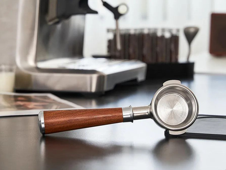 پرتافیلتر نیکد ۵۸ با دسته چوبی روی میز قهوهساز